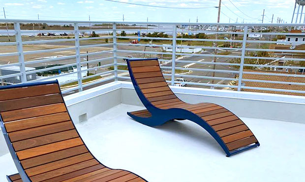 A pair of Loma Chaise Lounges on a rooftop viewing deck