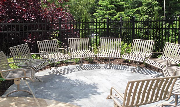 Custom Pullenium modular curved bench with arms in garden setting