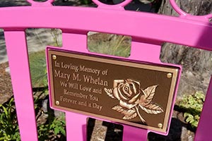 Memorial cast bronze plaque on the back of a Sienna Bench with personal messages attached